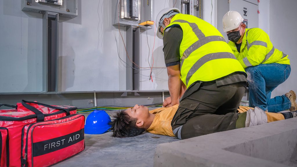 Workers giving CPR to a person.